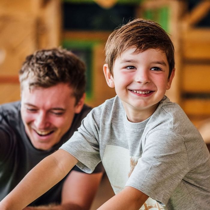 Father and son playing in kid's play area at Falkensteiner Hotel Sonnenalpe